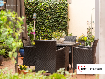 Gemütlicher Sitzbereich im Außenbereich zur Mitbenutzung | © AWO Bremerhaven Ein Gartentisch mit vier Stühlen umgeben von Pflanzen und einer grünen Hecke | © AWO Bremerhaven